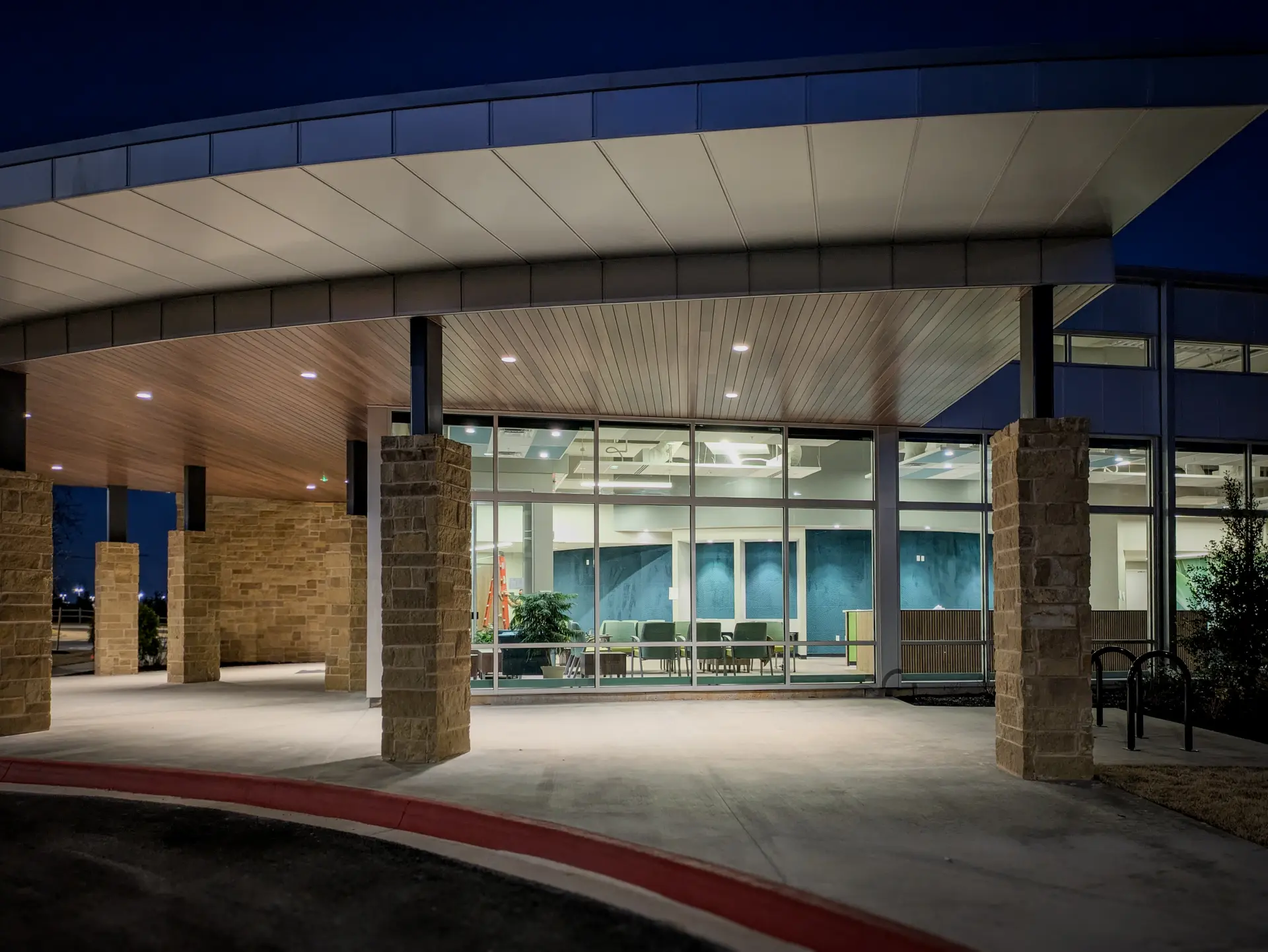 Entrance canopy and lobby of the Arisa Health Jane Hunt Clinic at night