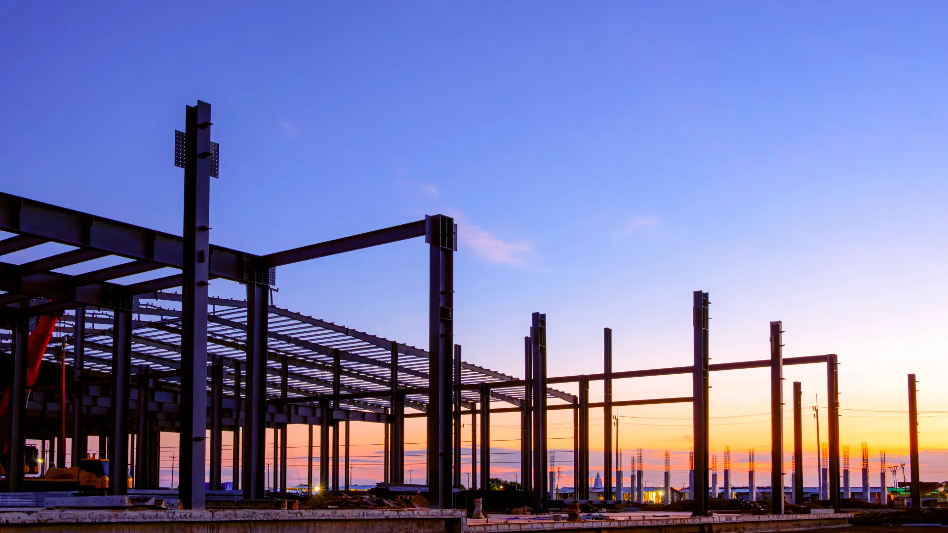 An industrial building under construction, with steel beams and concrete visible